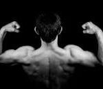 Black and white photo of a muscular man flexing arms against a dark background.