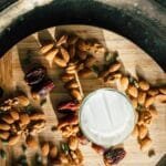 Flat lay of almonds, dates, and milk for iftar on a wooden board.