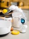 A sleek AI robot arm showcasing innovation by holding a lemon in a modern kitchen setting.